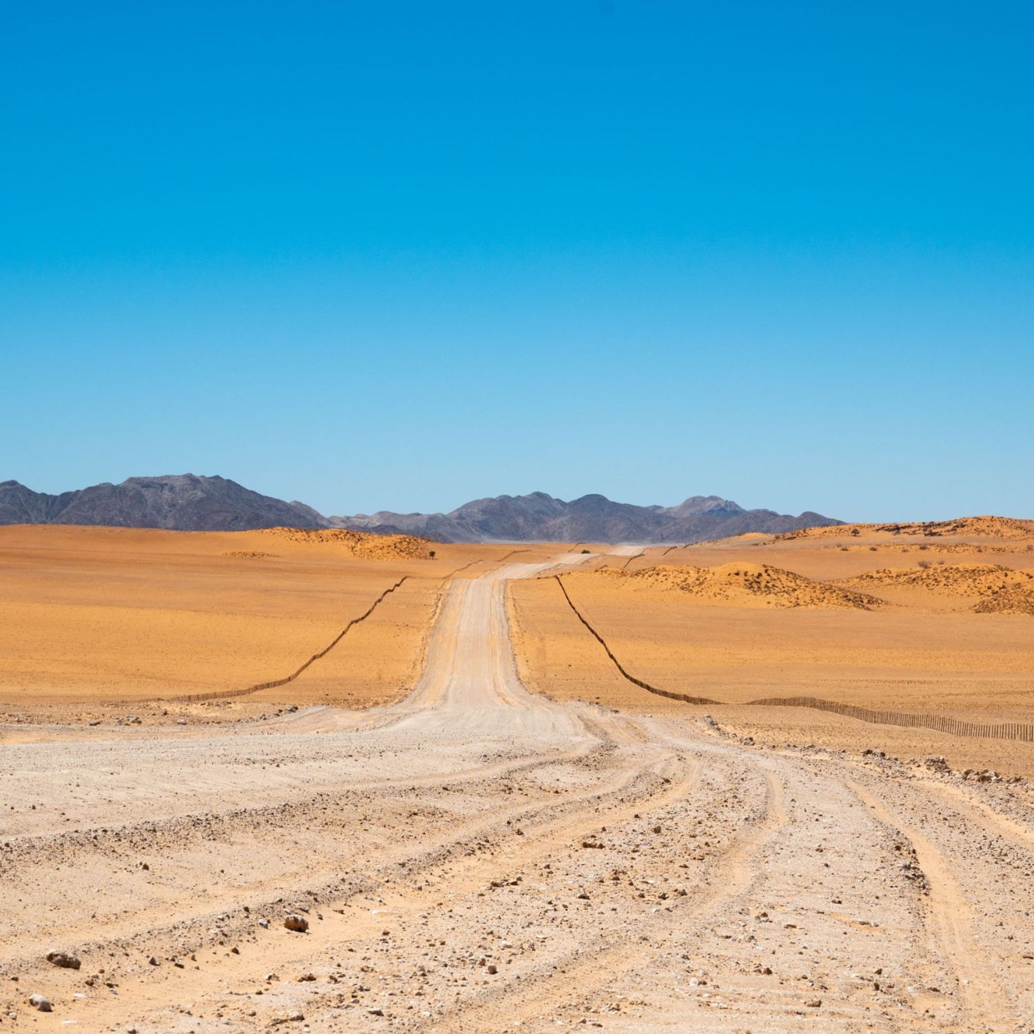 Sandstrasse durch Wüstenlandschaft